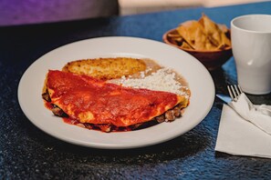 A plate of food with a slice of pizza and a side of rice. - Hotel Flores de Sal (Valle de Guadalupe)