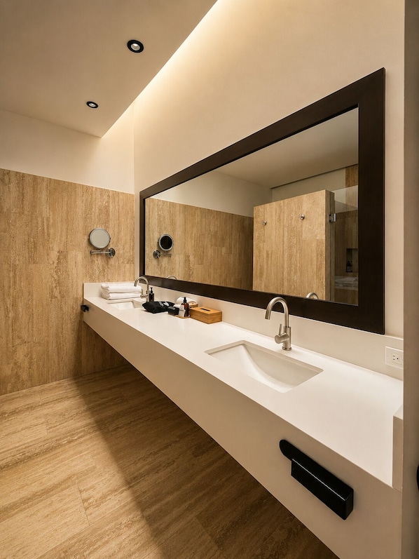 A modern bathroom with a long vanity, two sinks, a large mirror, and wooden wall panels. - Hotel Flores de Sal (Valle de Guadalupe)