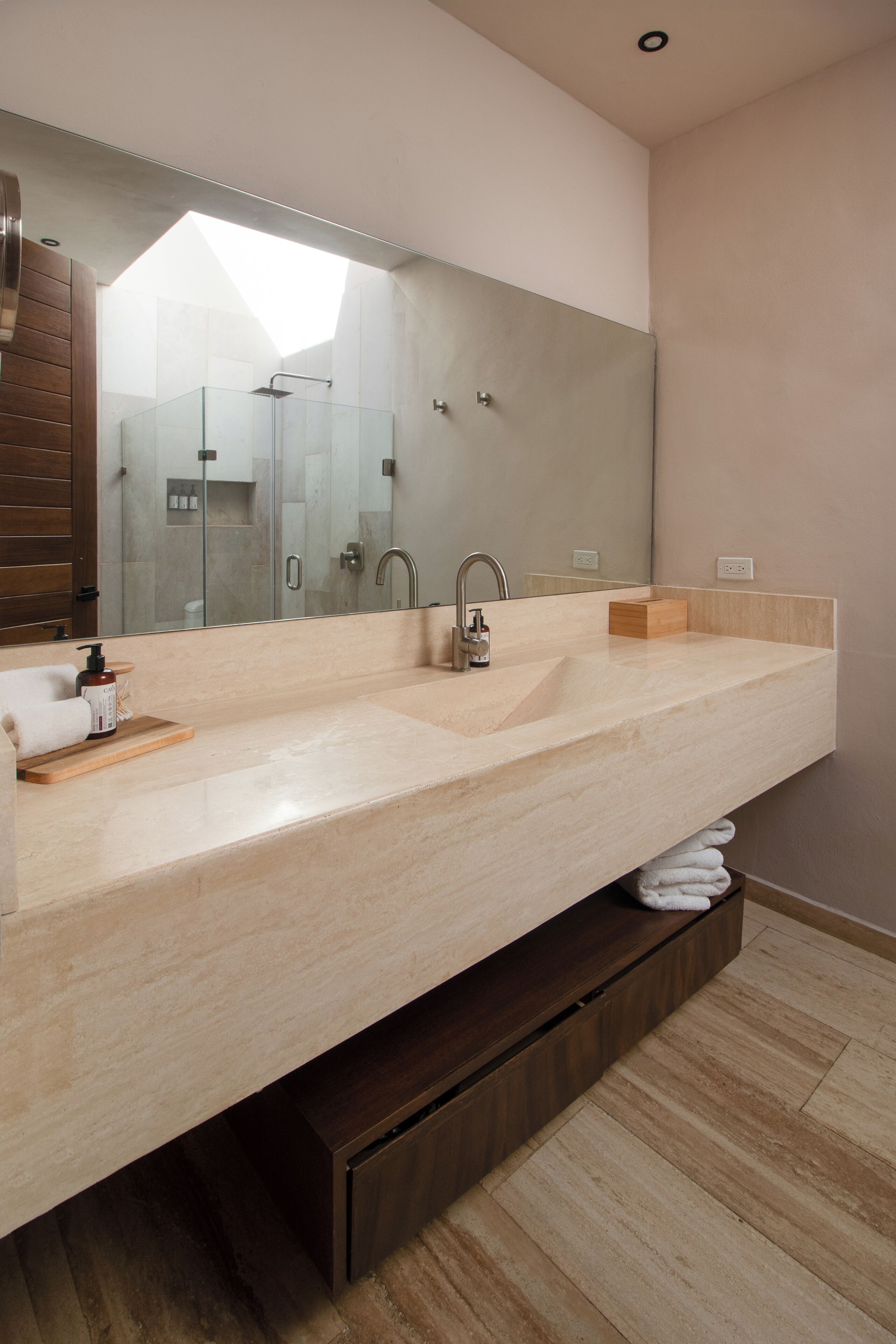 Un baño moderno con tocador doble lavamanos, un espejo grande y un toallero empotrado.