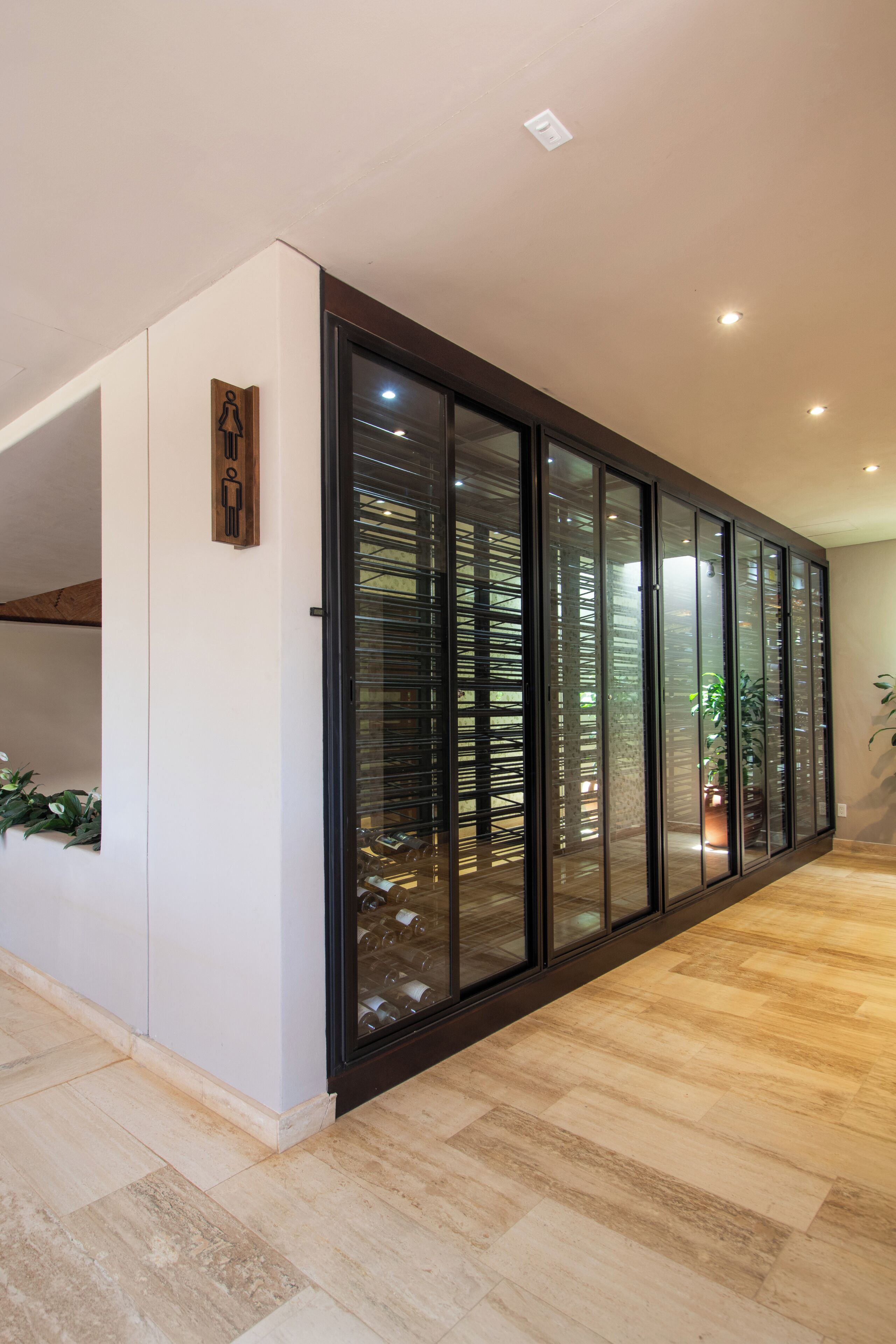Een modern interieur met een glazen scheidingswand, houten vloer en een bord aan de muur.