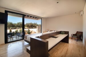 Un dormitorio moderno con un amplio ventanal corredero que da a un patio exterior.