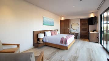 Habitación de hotel moderna con una cama grande, un escritorio, una silla y vistas a través de un ventanal.