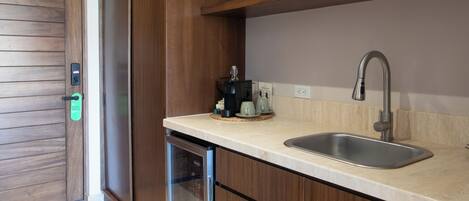 A modern kitchen with a built-in dishwasher, a stainless steel sink, and wooden cabinetry.