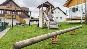 Et boligområde med træhuse, en trætrap og en græsplæde.