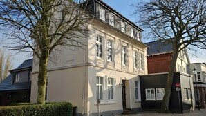 A two-story building with a traditional facade, large windows, and a gated entrance. - Apartment 'Hiddes Hus - Fuhrmann' with Wi-Fi (Borkum)