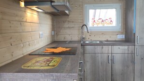 Une cuisine avec des meubles en bois, une fenêtre offrant une belle vue et un four encastré.