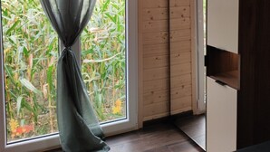 Une pièce dotée d’une grande fenêtre, de murs en bois et d’un rideau.