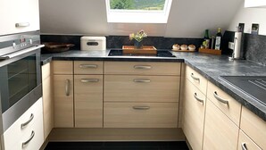 Una cocina moderna con tragaluz, horno empotrado y armarios de madera.
