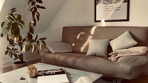 A cozy living room with a sofa, cushions, a coffee table, a potted plant, and a framed quote on the wall. - "Holiday Apartment Frida" in the heart of Burkheim (Vogtsburg)