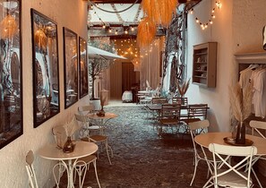 A cozy café with tables and chairs, framed artwork on the walls, and string lights. - "Holiday Apartment Frida" in the heart of Burkheim (Vogtsburg)