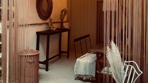 A cozy room with a dark wooden table, a wicker chair, a small table with a statue, and string lights. - "Holiday Apartment Frida" in the heart of Burkheim (Vogtsburg)