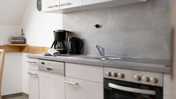 Een koelkast, een oven, een kookplaat, een vaatwasser