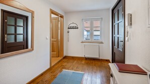 A hallway with wooden flooring, a radiator, a window, and a door. - Holiday Apartment "Kolibri" with Shared Terrace & Shared Garden (Naumburg (Saale))