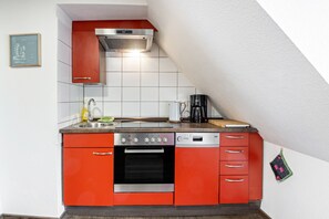 Una cocina equipada con horno, cafetera y tostadora.