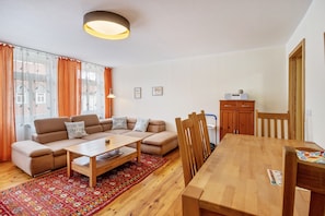 Una sala de estar con sofá, mesa de centro y mesa de comedor.