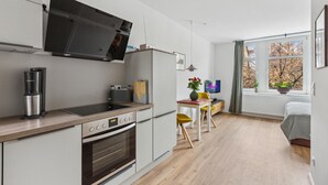 Een moderne keuken met een inbouwoven, een koffiezetapparaat en een televisie boven de aanrecht.