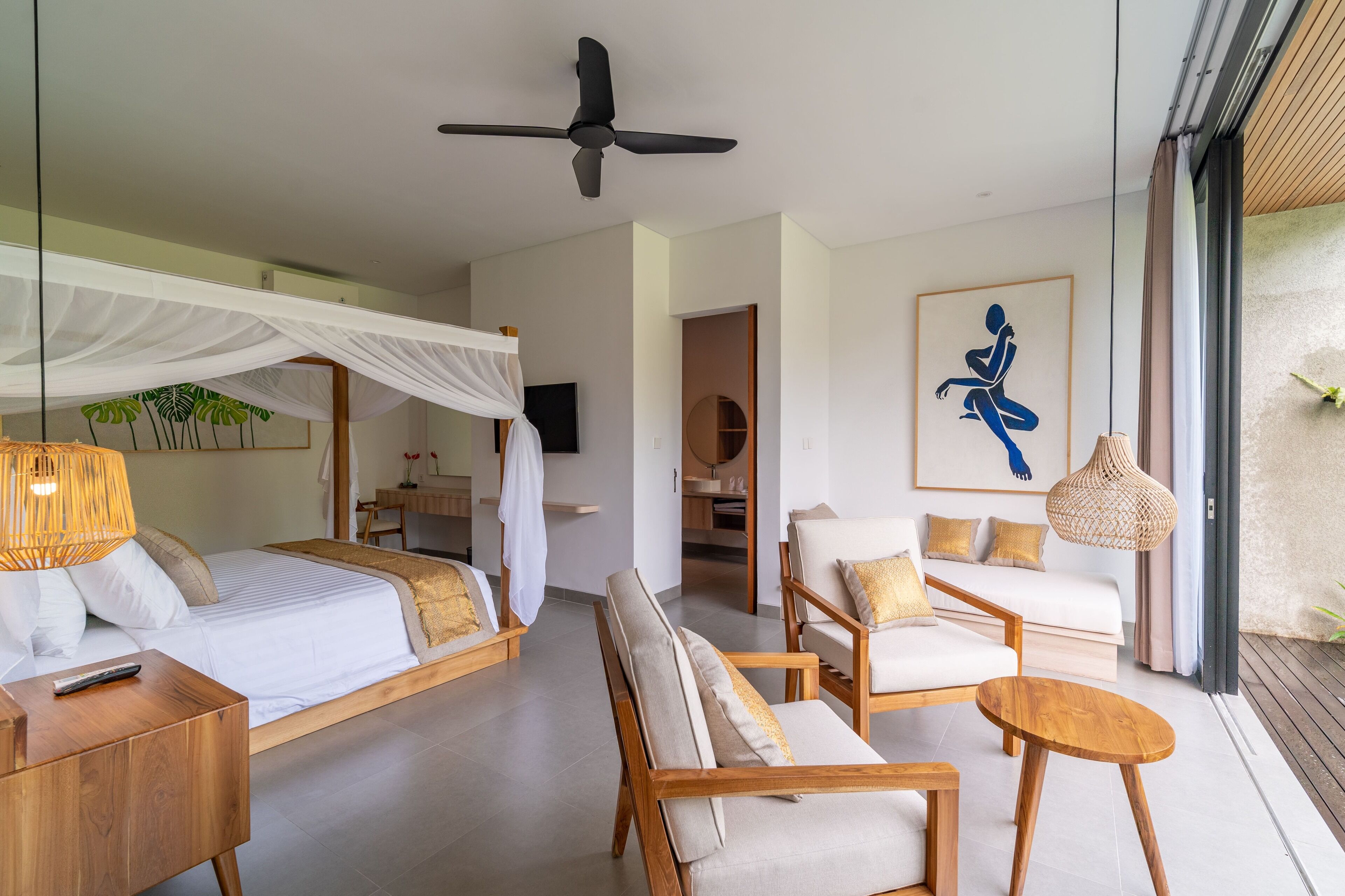 A modern bedroom with a canopy bed, a sofa, and a dining area.