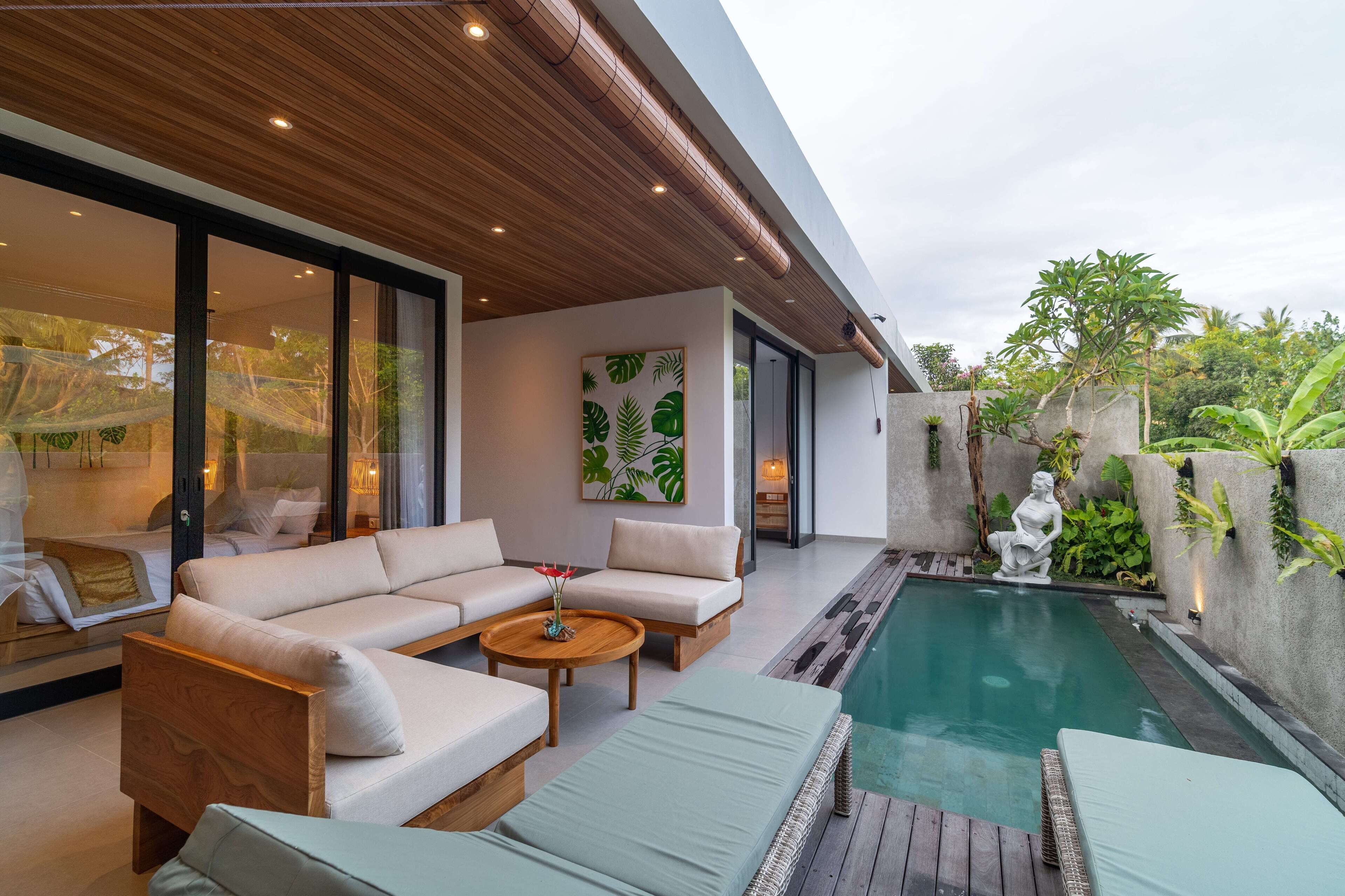 A modern outdoor living area with a pool, wooden furniture, and a statue.