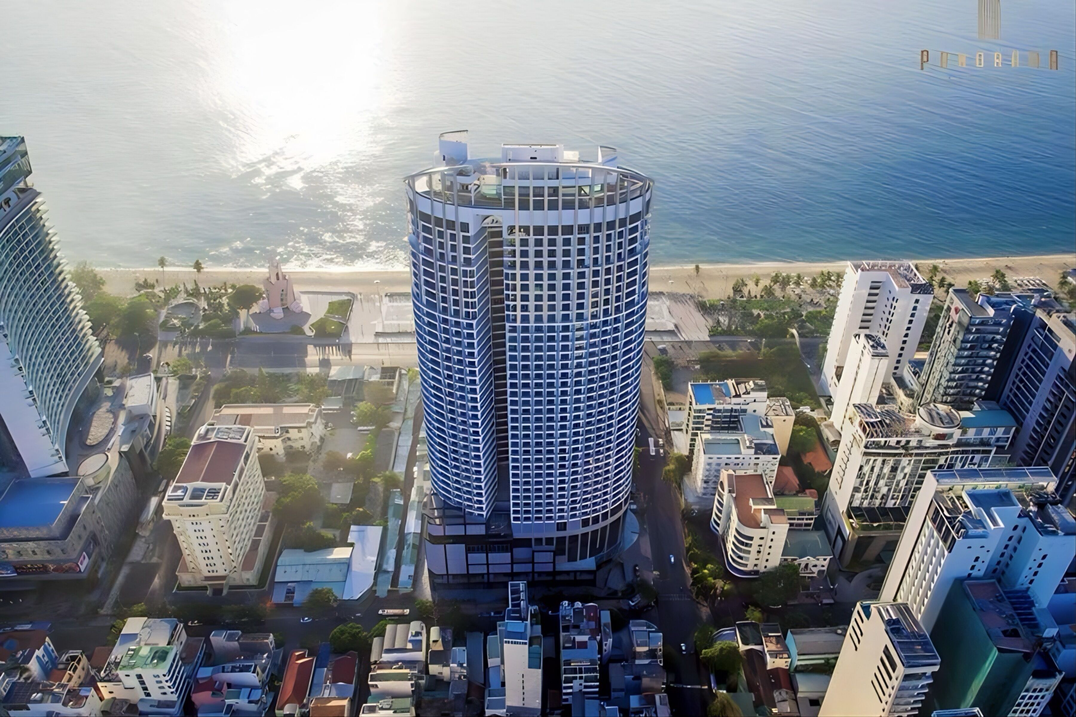 Un hotel moderno de gran altura con diseño cilíndrico, situado cerca de una playa.