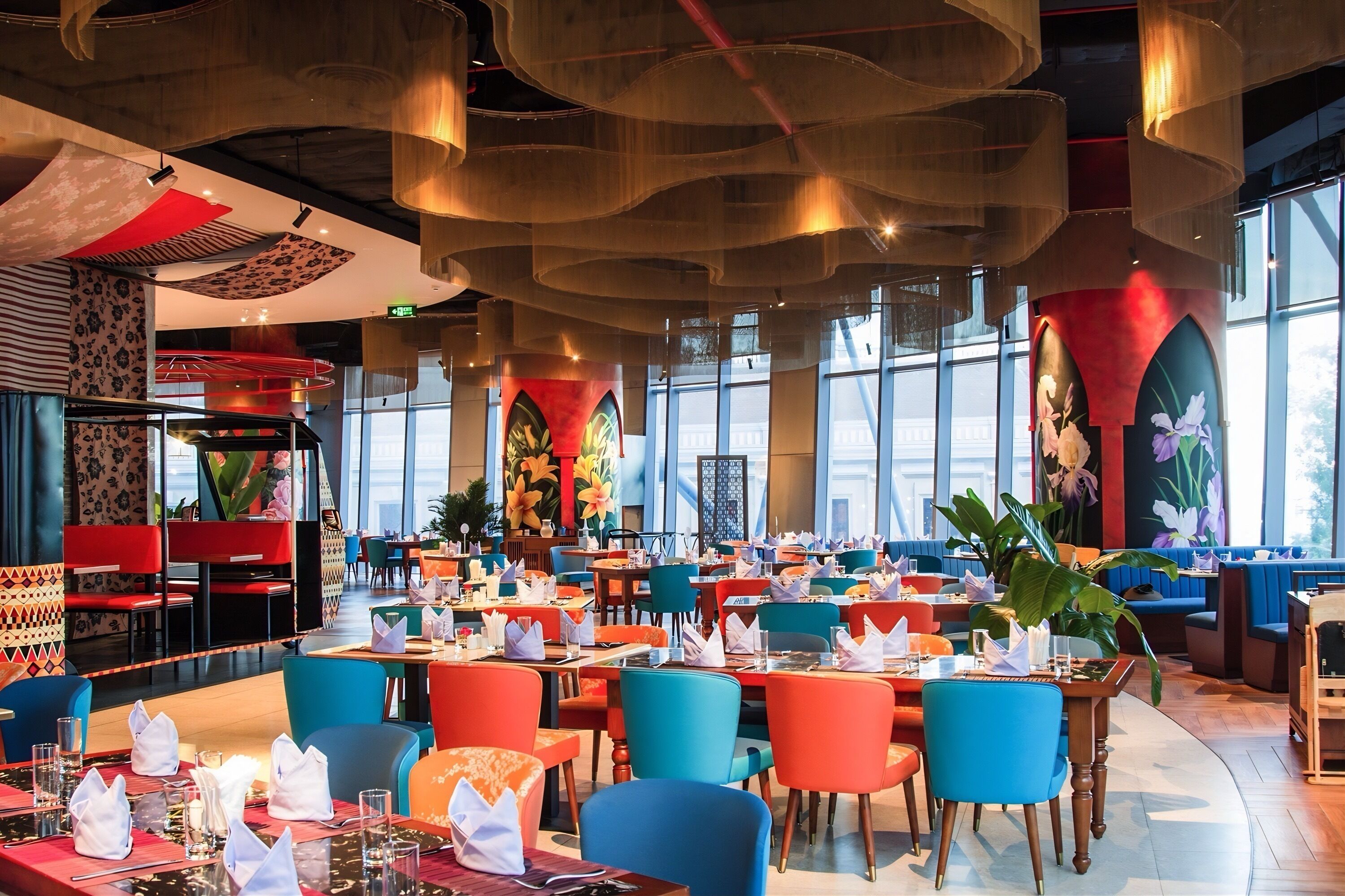 Un restaurante espacioso con techos altos, iluminación moderna y amplios ventanales.