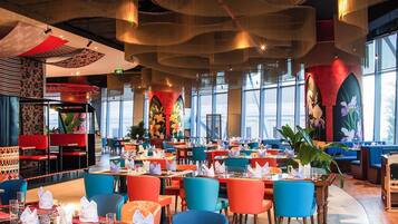 Un restaurante espacioso con techos altos, iluminación moderna y amplios ventanales.