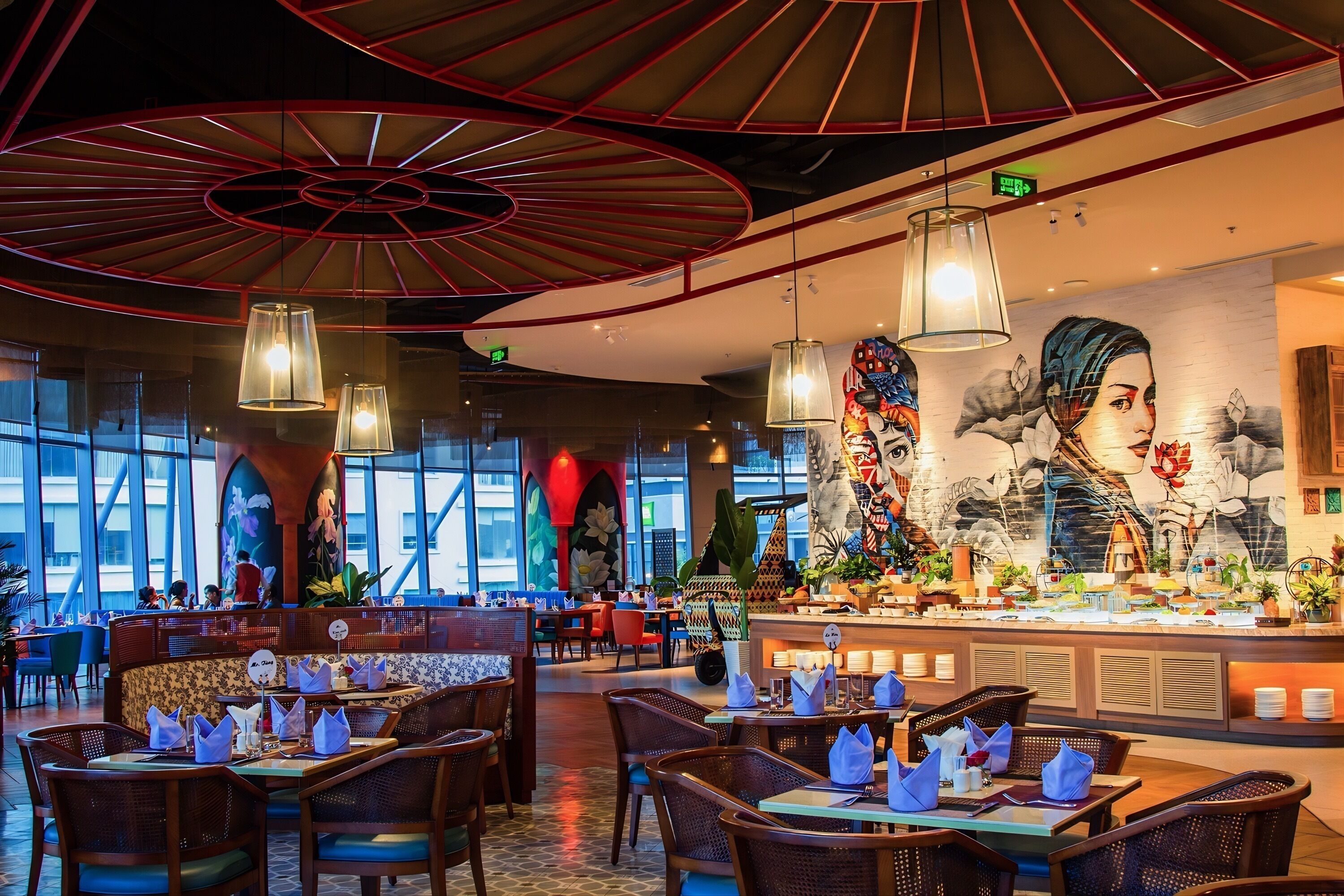 Un restaurant au décor moderne, agrémenté d’une fresque murale, d’un espace buffet et d’un plafond au design rouge original.