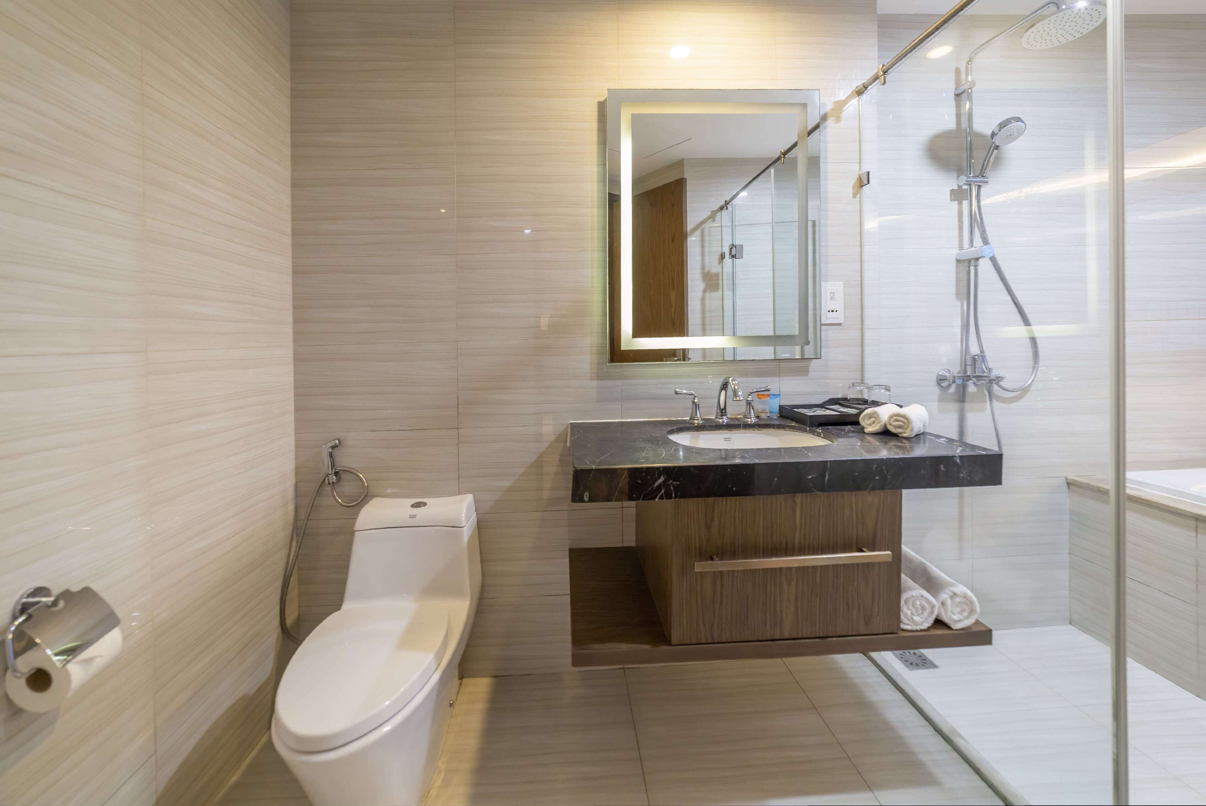 A modern bathroom with a toilet, sink, and shower.
