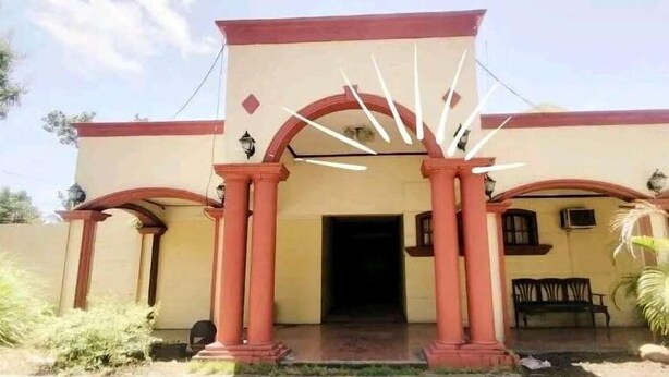 A building with a central entrance framed by red columns and a fanlight. - REGENCY PLAZA TOURIST INN (Bacolod)