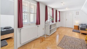 A spacious room with a large bed, a desk with a chair, and a radiator. - Old Town home by Interhome (Prague centre)
