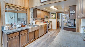 A kitchen with wooden cabinets, stainless steel appliances, and a large island. - Sunriver Resort Home: Near Skiing, Town & Trails (Sunriver)