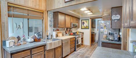 A kitchen with wooden cabinets, stainless steel appliances, and a large island.