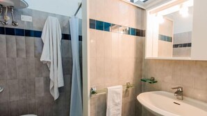 Et badeværelse med toilet, håndvask og bruser.
