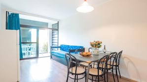 A dining area with a table, chairs, and a blue sofa. - Bilo Plus Garden by Interhome (Marina di Bibbona)