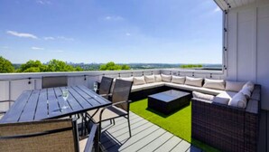 A rooftop patio with a dining table, chairs, a sofa, and a small table. - Luxury Home w/ Rooftop & 8 Beds! 10 to Downtown! (Nashville)