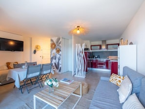 A modern living room with a sofa, coffee table, and a TV mounted on the wall. - La Croix du Sud by Interhome (Cavalaire)