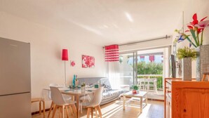 Une cuisine moderne avec un coin repas, un canapé et un balcon agrémenté de plantes.