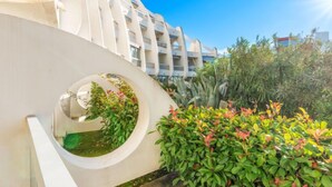 Un bâtiment moderne doté d’une fenêtre circulaire et d’une végétation luxuriante.