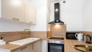 Eine moderne Küche mit Backofen, Mikrowelle, Spüle und Holzschränken.