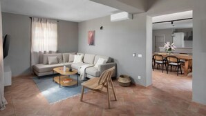 A modern living room with a sectional sofa, a coffee table, and a dining area with a wooden table and chairs. - Rorripa by Interhome (Poreč/Sv. Lovreč)