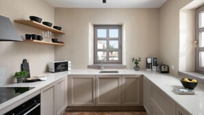 A modern kitchen with white cabinets, a microwave, a toaster, and a window above the sink. - Calluna by Interhome (Poreč/Sv. Lovreč)