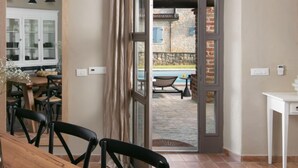 A room with a dining area, a white cabinet, and a view of an outdoor pool area. - Calluna by Interhome (Poreč/Sv. Lovreč)