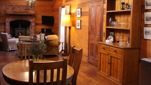 Un salon chaleureux avec une cheminée, des meubles en bois et une bibliothèque.