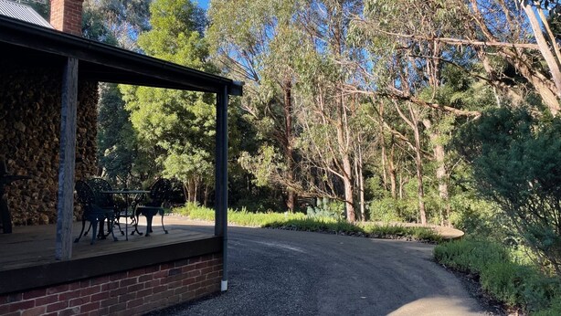Un espace extérieur abrité, doté d’un mur en briques et de mobilier en métal.