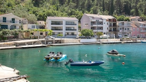 A coastal town with buildings along the waterfront, a marina with boats, and a clear view of the sea. - Lovely apartment in Blace with WiFi (Blace)