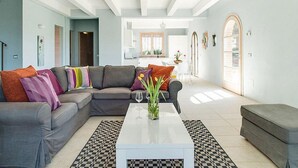 Ein modernes Wohnzimmer mit einem Ecksofa, einem Couchtisch und einem karierten Teppich.