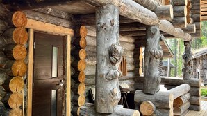 A log cabin with a wooden door and a deck area.