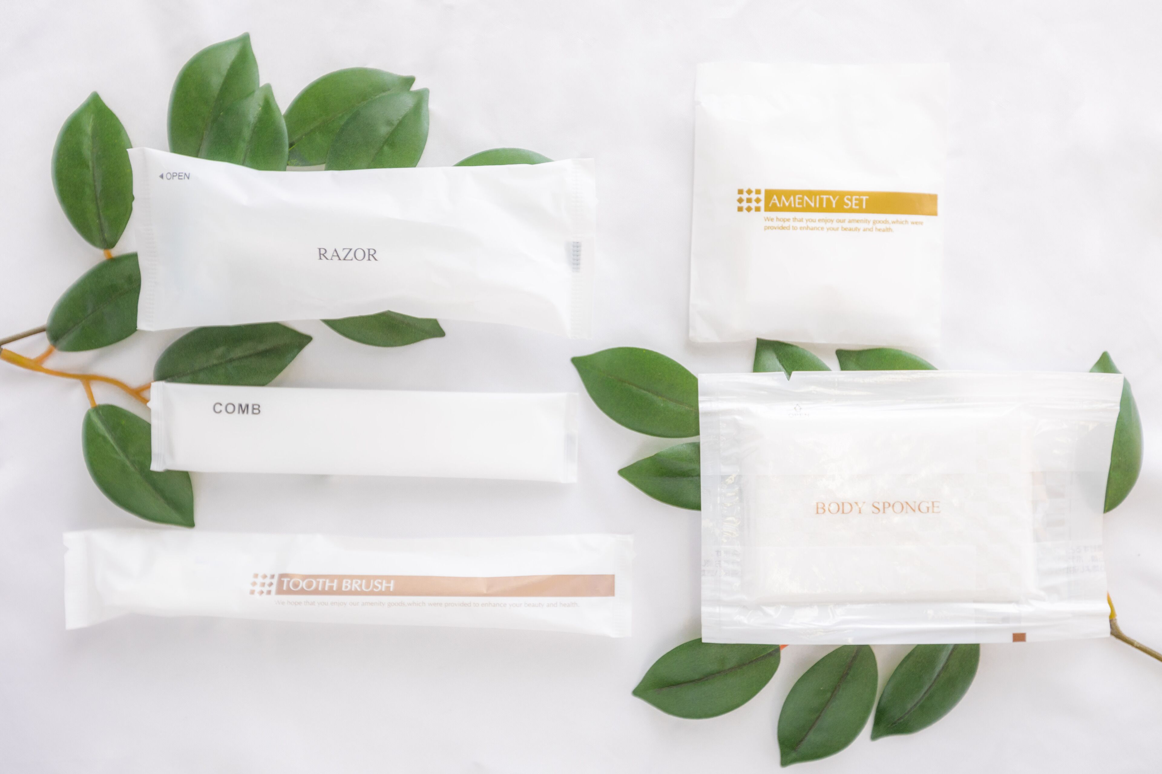 A set of toiletries including a razor, comb, toothbrush, body sponge, and amenity set.
