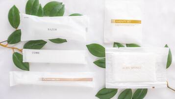 A set of toiletries including a razor, comb, toothbrush, body sponge, and amenity set.