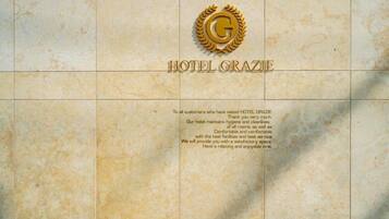 Hotel Grazie proudly displays its emblem featuring a laurel wreath and the letter 'G', showcasing its commitment to exceptional service and facilities.