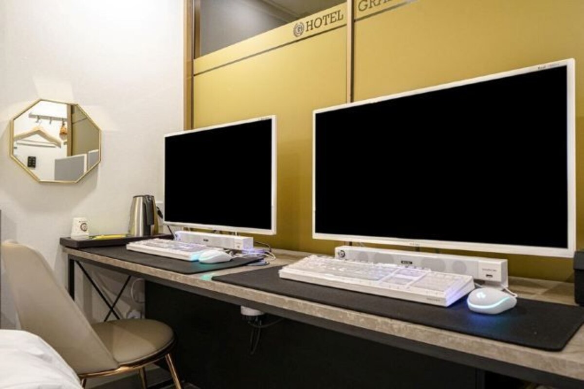 Un mostrador de recepción de hotel con dos monitores de computadora, un teclado y un ratón.